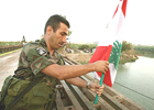 Un soldado del Lbano coloca una bandera en el puente del ro Litani