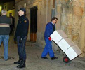 Un operario saca tres cajas de documentos en presencia de la polica