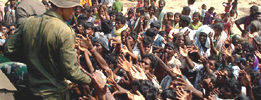 Un soldados del Ejrcito de Sri Lanka reparte comida entre los desplazados 