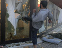 Un luchador rebelde rompe el cristal de uno de los edificios del cuartel general de Gadafi en Trpoli.