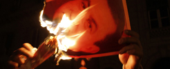 Un manifestante quema una foto de Hosni Mubarak