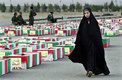 Una mujer iran camina junto a un numeroso grupo de atades de soldados, que fallecieron en la guerra Irn-Irak 1980-89.