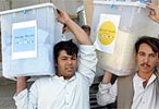 Dos funcionarios afganos trasladan los votos desde un colegio electoral de Kabul
