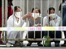 Tres mujeres, protegidas por mascarillas, observan el exterior desde detrs de la reja del Hospital de la Universidad Popular de Pekn, que se encuentra desde en cuarentena.