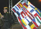 Un hombre cruza la frontera entre Alemania y Polonia con las banderas de todos los miembros de la nueva Unin Europea.