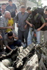 Un militante de Hamas, con el rostro cubierto, inspecciona los restos de un coche destruido por los helicpteros israeles