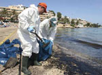 Operarios del servicio de limpieza municipal retiran el fuel que durante esta tarde esta llegando a la playa de Ses Figueretes, en Ibiza
