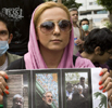 Una manifestante, con fotografas y carteles del candidato Musavi