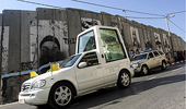 El "papamovil", pasando junto al muro de Cisjordania