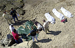 Agentes de la Guarcia Civil preparan seis de los trece cadveres localizados en una playa de Tarifa para su traslado al cementerio de Algeciras.