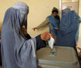 Una mujer afgana tapada con su burka por primera vez en su vida deposita el voto en una urna